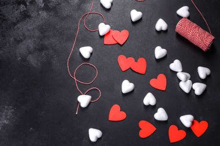 Beautiful background with white and red hearts on a dark table. Preparing for Valentine's Dayの写真素材