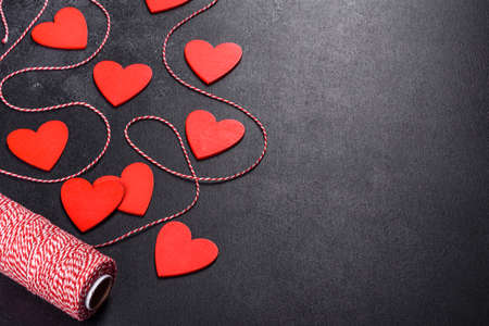 Beautiful background with white and red hearts on a dark table. Preparing for Valentine's Dayの写真素材