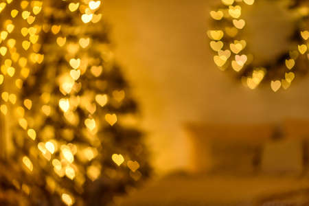 A lot of golden lights in the shape of hearts in the defocus on a dark background. Celebrating Valentine's Dayの写真素材