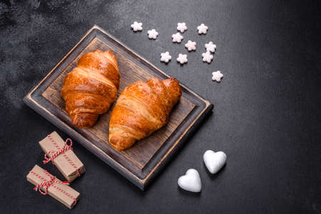 Delicious fresh crispy croissants on a dark concrete background. Tasty breakfastの写真素材