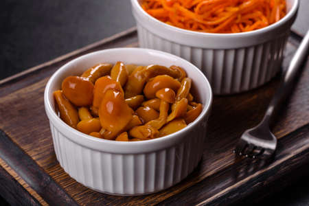 Canned mushrooms in a bowl on a dark backgroundの写真素材