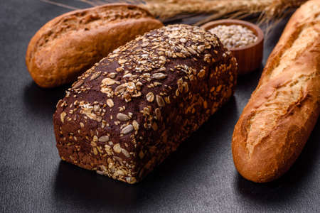 Fresh Bread on black background, top view, copy space. Homemade fresh baked various loafs of wheat...
