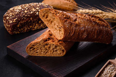 Fresh Bread on black background, top view, copy space. Homemade fresh baked various loafs of wheat...