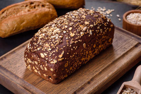Fresh Bread on black background, top view, copy space. Homemade fresh baked various loafs of wheat...