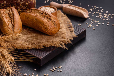 Fresh Bread on black background, top view, copy space. Homemade fresh baked various loafs of wheat...