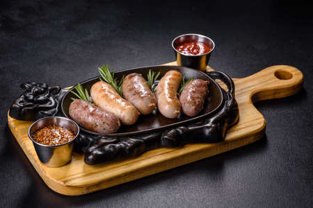 Delicious fresh juicy sausages grill with red sauce in a beautiful cast iron pan. Beer snacksの写真素材
