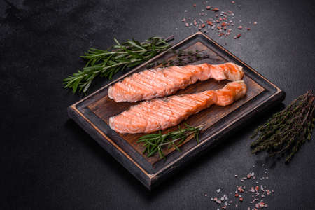 Grilled salmon fillets with salt pepper and herb decorationの写真素材