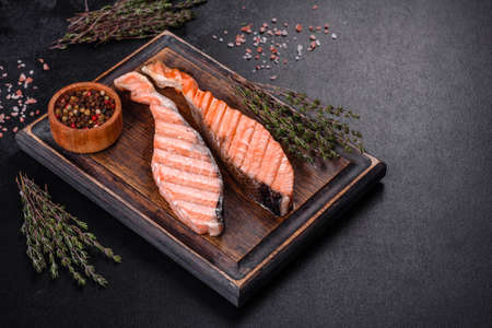 Grilled salmon fillets with salt pepper and herb decoration