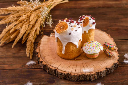 Festive cakes with white glaze, nuts and raisins on the festive table. Preparations for Easter