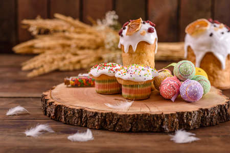 Festive cakes with white glaze, nuts and raisins on the festive table. Preparations for Easter