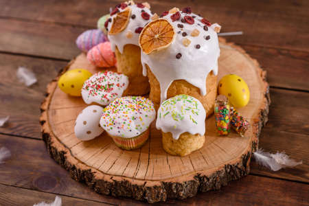 Festive cakes with white glaze, nuts and raisins on the festive table. Preparations for Easter