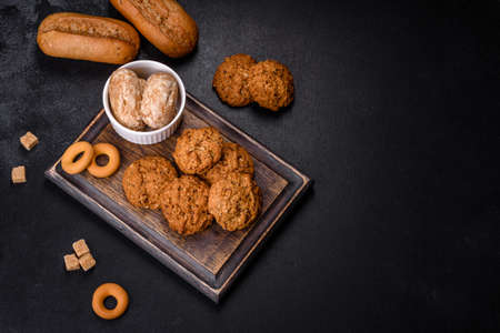 Tasty fresh oat cookies on a dark concrete background. Delicious wholesome sweetsの写真素材