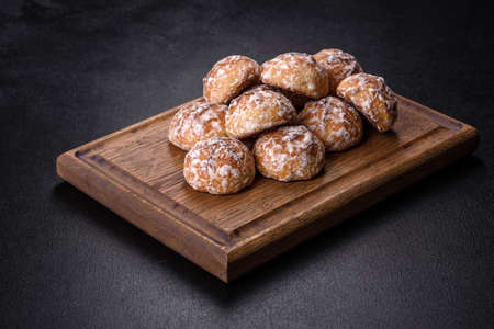Plate with tasty homemade gingerbread cookies on dark concrete table