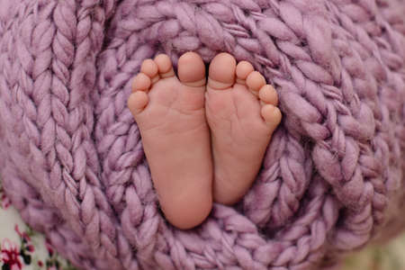 Small beautiful legs of a newborn baby in the first days of life. Baby feet of a newbornの写真素材