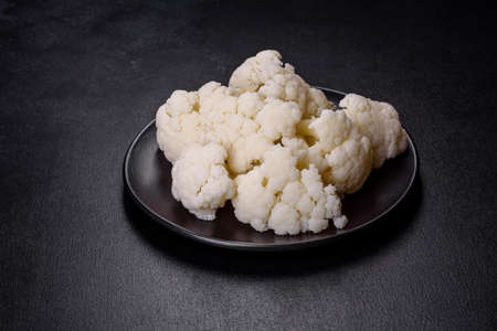 Beautiful swing of fresh white cauliflower on a dark concrete background. Crop in the home gardenの写真素材
