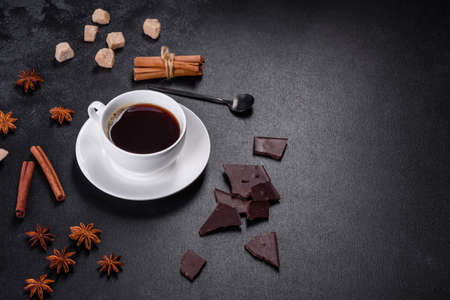 Broken black chocolate pieces with star anise and cinnamon on black backgroundの写真素材
