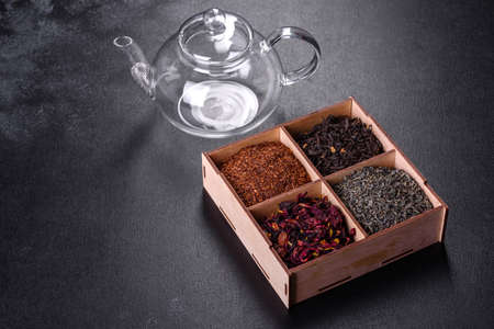 Different kind of Dry tea - green, black, mint, rose and chamomile, wooden spoon in the box