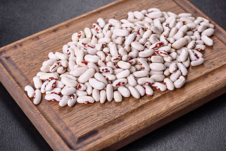 White dry raw beans on a dark concrete background. Cooking Healthy Food