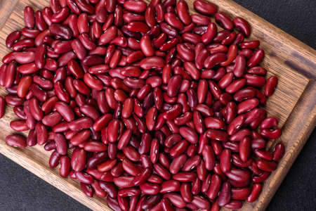 Beans of red dry raw beans on a dark concrete background. Cooking Healthy Food
