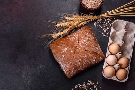 Beautiful tasty, square-shaped brown bread on a dark concrete background. Baking bread at home