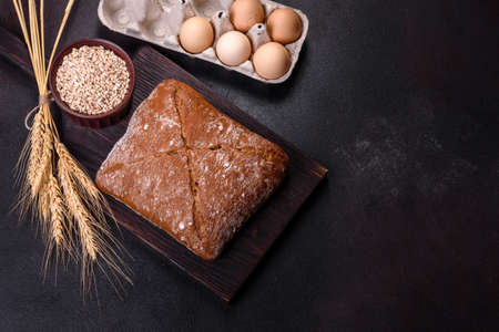 Beautiful tasty, square-shaped brown bread on a dark concrete background. Baking bread at home