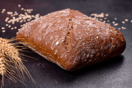 Beautiful tasty, square-shaped brown bread on a dark concrete background. Baking bread at home