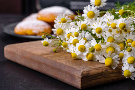 Garden camomile flowers bouquet on a yellow concrete table. Top view flat lay with copy spaceの写真素材