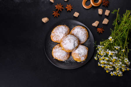 Homemade golden brown corn cookies on a black background