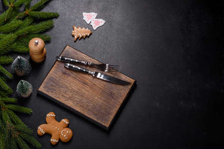 An empty wooden cutting board with wooden cutlery. Preparing the christmas kitchen table for cookingの写真素材