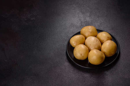 A pile of young potatoes on the table. The benefits of vegetables. Harvest and natural productsの写真素材