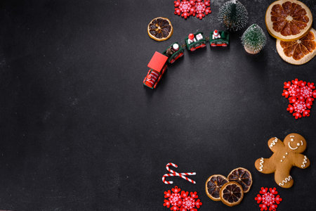 Delicious fresh chocolate biscuits on a dark concrete background with Christmas toys, dried citrus...