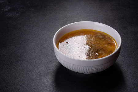 Mushroom soup plate with porcini mushrooms, fresh parsley and pepper on rustic texture backgroundの写真素材