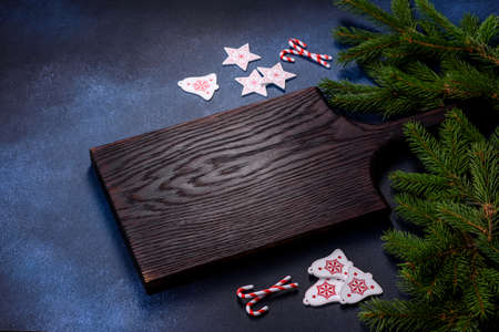 Crispy chocolate croissant with Christmas decorations on wooden cutting board on dark concrete backgroundの写真素材