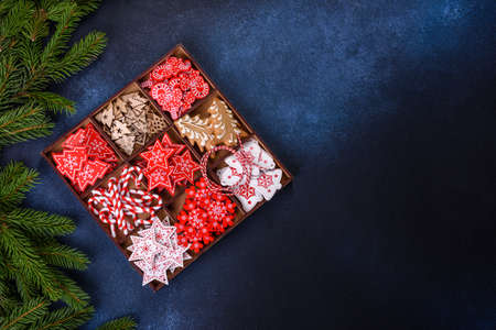 Christmas toys in white and red in a wooden sectional box against a dark concrete background. Home decorations for Christmas holidayの写真素材