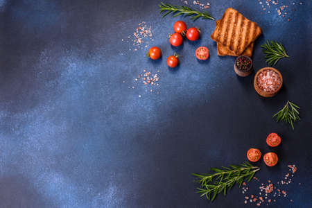 Delicious roasted ham with slices on a wooden cutting board with spices and herbs. Making a hearty...