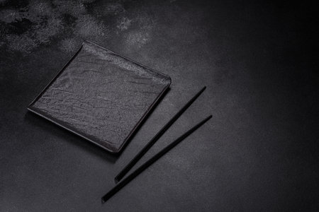 Empty square black plate over dark slate. Aerial view, with copy spaceの写真素材