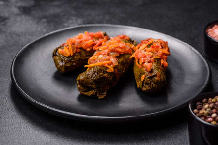 Dolma, stuffed grape leaves with rice and meat on a dark background. Caucasian and Turkish cuisine