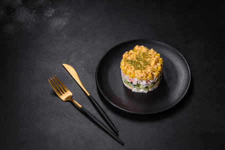 Crab salad with corn, laid out on a black plate for portion serving in a festive table settingの写真素材