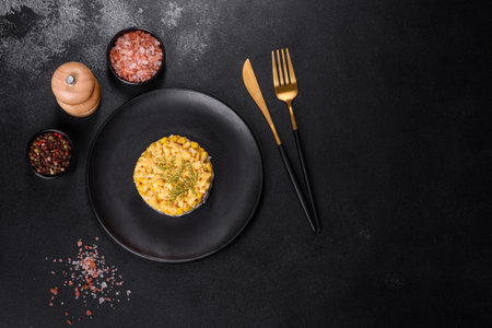 Crab salad with corn, laid out on a black plate for portion serving in a festive table settingの写真素材