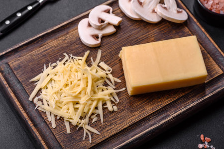 Raw pasta, mushrooms, onions, mince, spices and herbs to make a delicious paste with tomato sauce against a dark concrete backgroundの写真素材