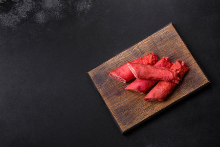 Delicious fresh red pancakes topped with beetroot juice with cheese and eggs on a dark concrete backgroundの写真素材