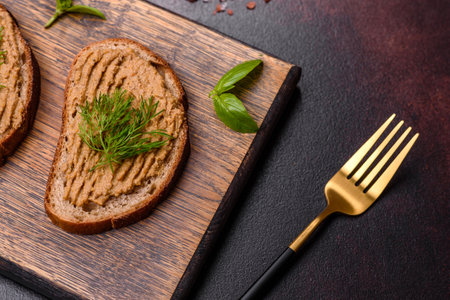 Chicken liver pate with bread on a wooden board over concrete backgroundの写真素材