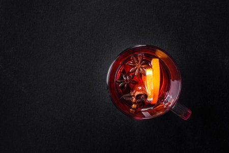 Christmas mulled red wine with spices and fruits on a concrete table. Traditional hot drink at...