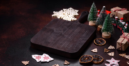 Home festive Christmas table decorated by toys and gingerbreads on a dark concrete background