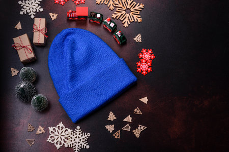 Blue knitted warm cap on dark brown concrete background. Clothes for a cold time of year