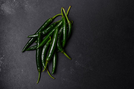 Hot pepper of green color on a dark concrete background. mexican food dishesの写真素材