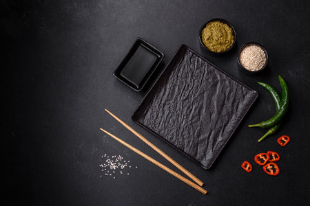 Empty plate with wooden sticks for Asian food on a dark concrete background. Asian cuisine preparationの写真素材