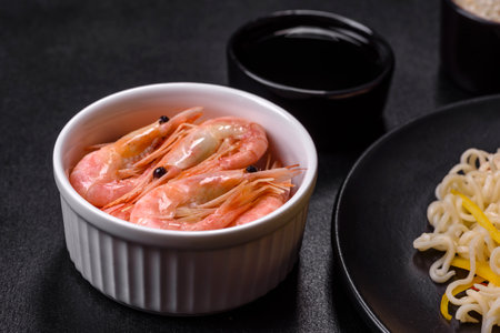 Delicious fresh rice noodles with shrimp, spices and herbs on a dark concrete backgroundの写真素材
