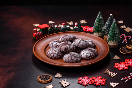 Delicious fresh brownies with Christmas decorations on a dark concrete background. Preparation of...