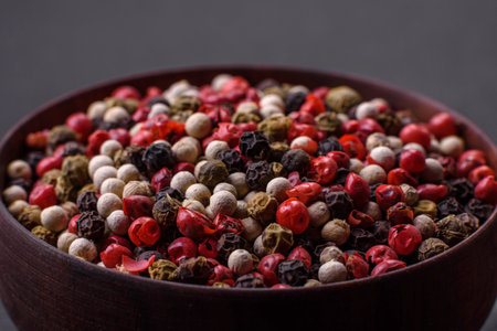 Allspice peas in a wooden bowl on a black concrete background. Preparing spices for cooking at homeの写真素材
